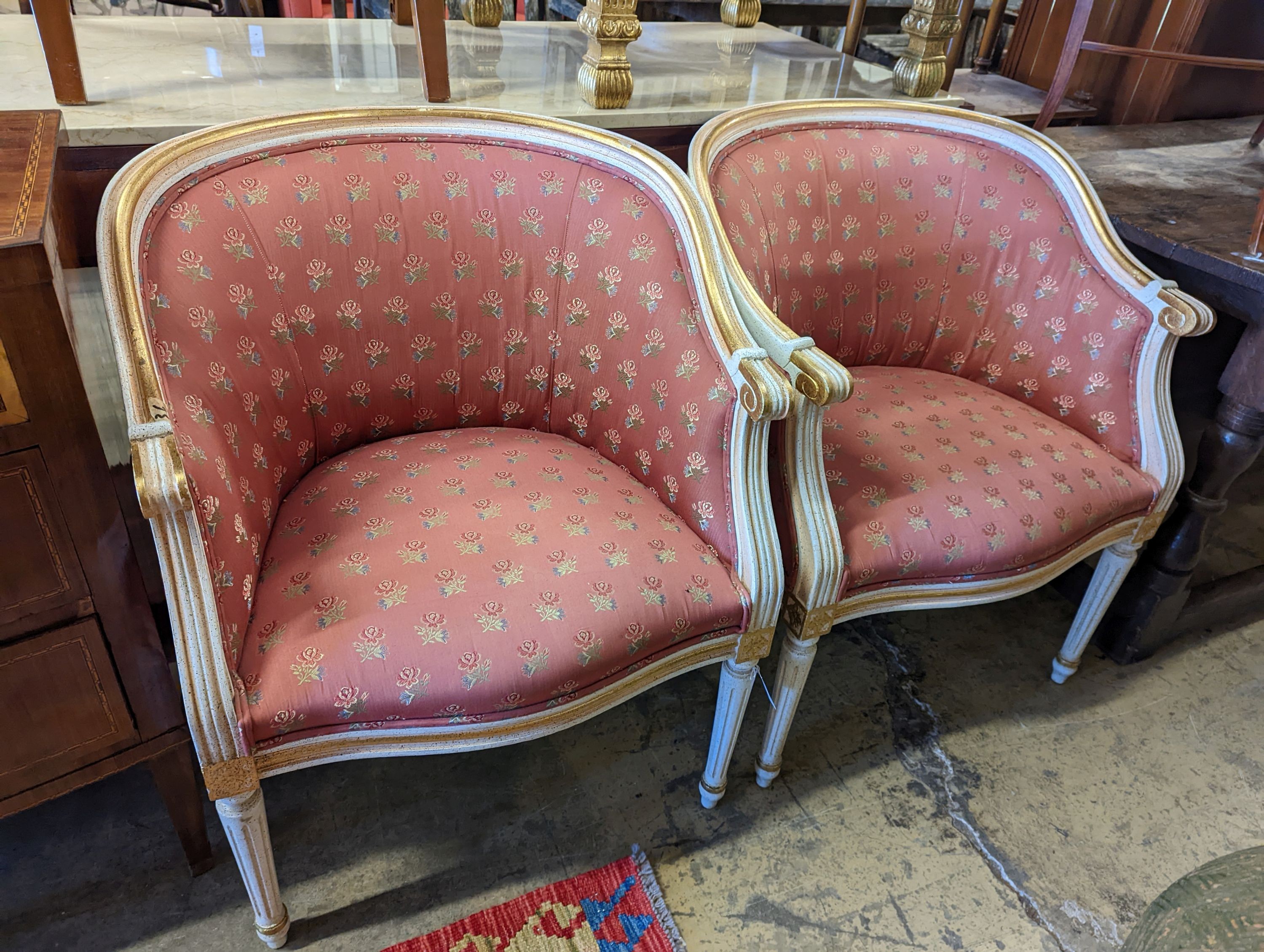 A pair of Louis XVI design painted parcel gilt tub framed chairs, width 65cm, depth 45cm, height 81cm